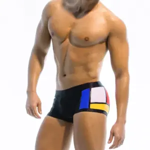 Nahaufnahme von farbenfrohen, geometrischen Herren-Badeshorts vor weißem Hintergrund.
