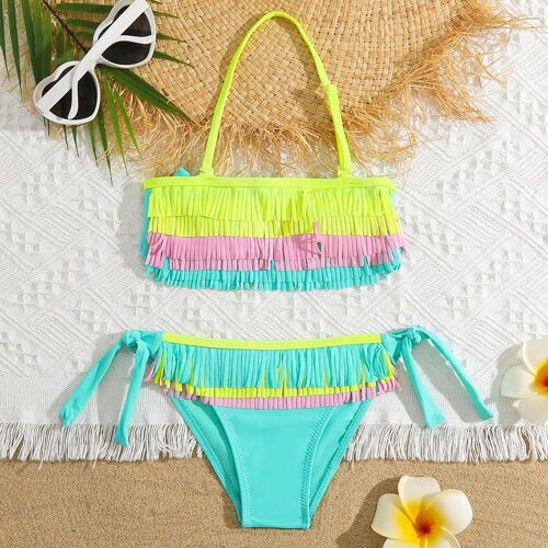 Fransenbikini auf Strandtuch mit Sonnenbrille und Blumen. Fransenbikini auf Strandtuch mit Sonnenbrille und Blumen.
