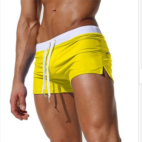Person trägt leuchtend gelbe Shorts mit weißem Bund und Kordelzug. Person trägt leuchtend gelbe Shorts mit weißem Bund und Kordelzug.