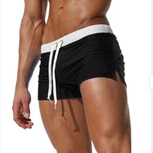 Mann trägt schwarze Badehose mit weißem Bund und Kordelzug.