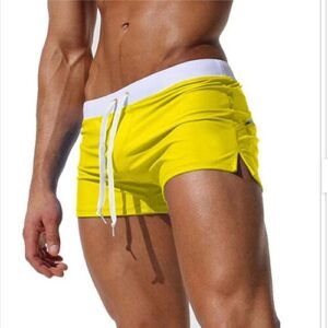 Person trägt leuchtend gelbe Shorts mit weißem Bund und Kordelzug.